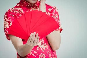 Asian woman holding red envelope, woman wear cheongsam, chinese new year photo