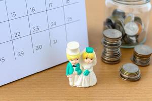 Miniature married couple on the calendar. concept for wedding valentine Day photo