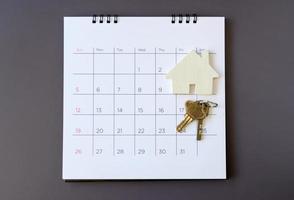 Calendar and house on table. Day of buying or selling a house or payment for rent or loan. photo