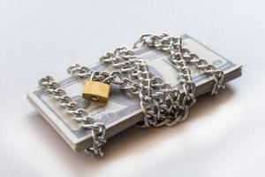 billetes de dólar con cadena y candado, dinero de seguridad y concepto de inversión. foto
