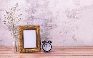 Picture frame and flowers and clock on wooden table. Poster product design styled photo