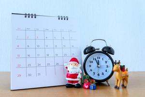 calendario y santa en la mesa. feliz año nuevo y concepto de navidad foto