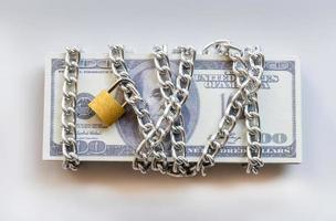 billetes de dólar con cadena y candado, dinero de seguridad y concepto de inversión. foto