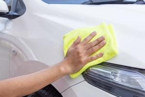 Hombre limpiando el coche con un paño de microfibra foto
