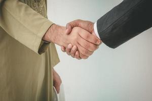 Arab businessman and businessman worker handshaking photo