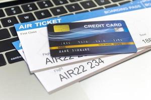 Credit card and passports near laptop computer on table. Online ticket booking concept photo