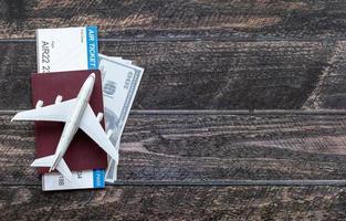 Toy airplane, Air Ticket, credit cards, dollars and passport on wooden table. Travel concept photo