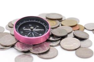 compass and coins on white background photo