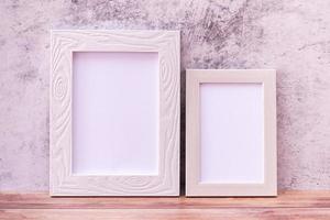 Two Picture frame on wall background and wooden table. Poster product design styled photo