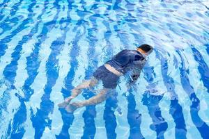 Young boy drowning in the pool photo