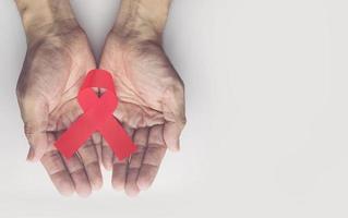 Man holding red aids ribbon,HIV photo