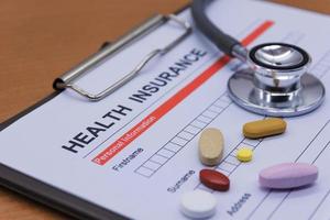 Health insurance paperwork, medicine, stethoscope. Health insurance claim concept. photo
