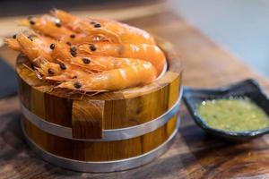 Plate with tasty shrimps on table photo