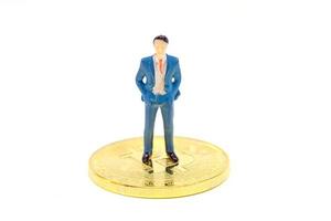 Miniature businessman and Bitcoin on white background photo