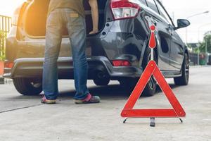 señal de coche rota en una carretera con un coche averiado foto