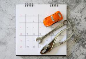 llave y coche en el calendario con números. concepto de reparación foto