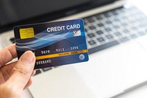 Man holding credit card on laptop. On-line shopping on the internet using a laptop photo