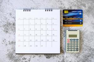 calendario con días y tarjeta de crédito en la mesa. concepto de compras foto