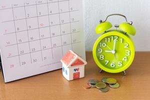 Calendar and house on table. Day of buying or selling a house or payment for rent or loan. photo