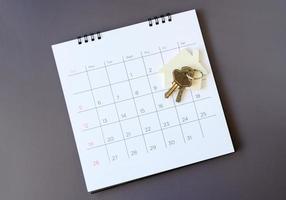 Calendar and house on table. Day of buying or selling a house or payment for rent or loan. photo