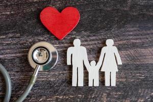 Red heart, stethoscope and icon family on wooden desk. Medical Insurance Concept photo