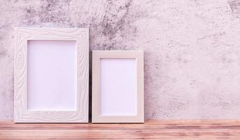 Two Picture frame on wall background and wooden table. Poster product design styled photo