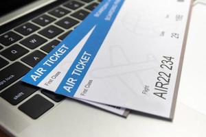 laptop computer and Air tickets on table. Online ticket booking concept photo