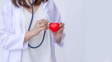 médico con estetoscopio examinando el corazón rojo foto