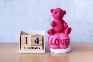 oso de peluche con calendario de madera 14 de febrero. día de San Valentín foto