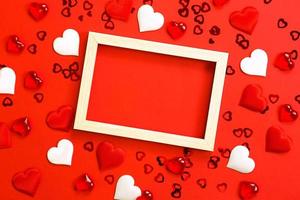 Text or photo frame in the center, surrounded by hearts. Decor of couples in love with hearts on a red background. Valentine's Day, message, greeting, declaration of love. Copy space