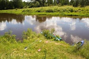 River in summer on a sunny day, green grass and forest. Reflection in the water. Domestic tourism, ecotourism, unity with nature. Clean environment, protection. Water hiking and camping. Summertime. photo