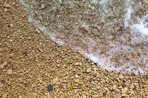 Sea wave on a pebble beach made of small stones. Sea holidays, travel background photo