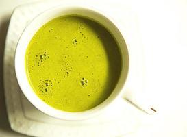 Japanese matcha green tea is poured into a white mug and on a white saucer in powder. Tea set on a textured napkin. Invigorating drink in a cafe, cooking, cheerfulness, antioxidant. space for text photo