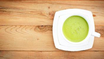 Japanese matcha green tea is poured into a white mug and on a white saucer in powder. Tea set on a textured napkin. Invigorating drink in a cafe, cooking, cheerfulness, antioxidant. space for text photo