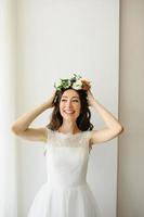 Beautiful bride tries on a wreath on her head. photo