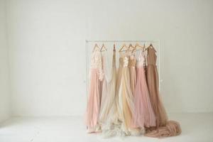 Designer wedding dresses hang on a hanger in a white studio. photo