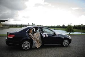 The bride hid in a car due to the abrupt rain. photo