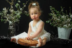 niña celebra su primer cumpleaños. niña comiendo su primer pastel. foto