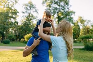 Parents play in the park with their son photo