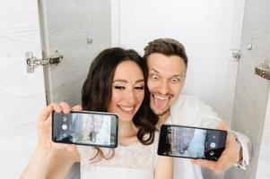 The bride and groom take a selfie in the closet. photo