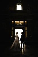 Silhouette of a bride and groom on the background of the exit from the church. photo