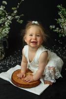 Little girl celebrates her first birthday. Girl eating her first cake. photo