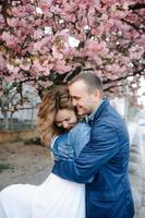 couple in love in a blooming Apple orchard lying on the blanket photo