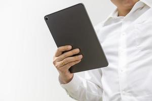 Asian businessman wearing white shirt holding a computer tablet on white background with copy space. photo