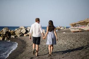 Young couple walking on the background of the sea on the island of Santorini photo