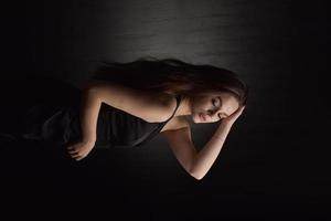 Beautiful Woman in Black Dress on black Backgound photo