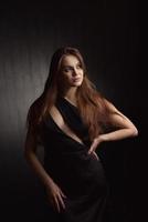 Beautiful Woman in Black Dress on black Backgound photo