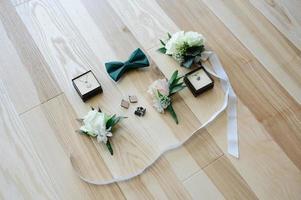 close up view of white flowers, wedding rings in rustic box with plants inside photo