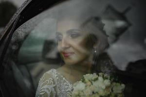 Beautiful blonde bride looks out the car window. Rainy weather. photo