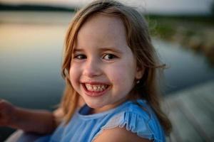 una niña pequeña tiene un postre en sus manos y quiere comerlo mucho. foto